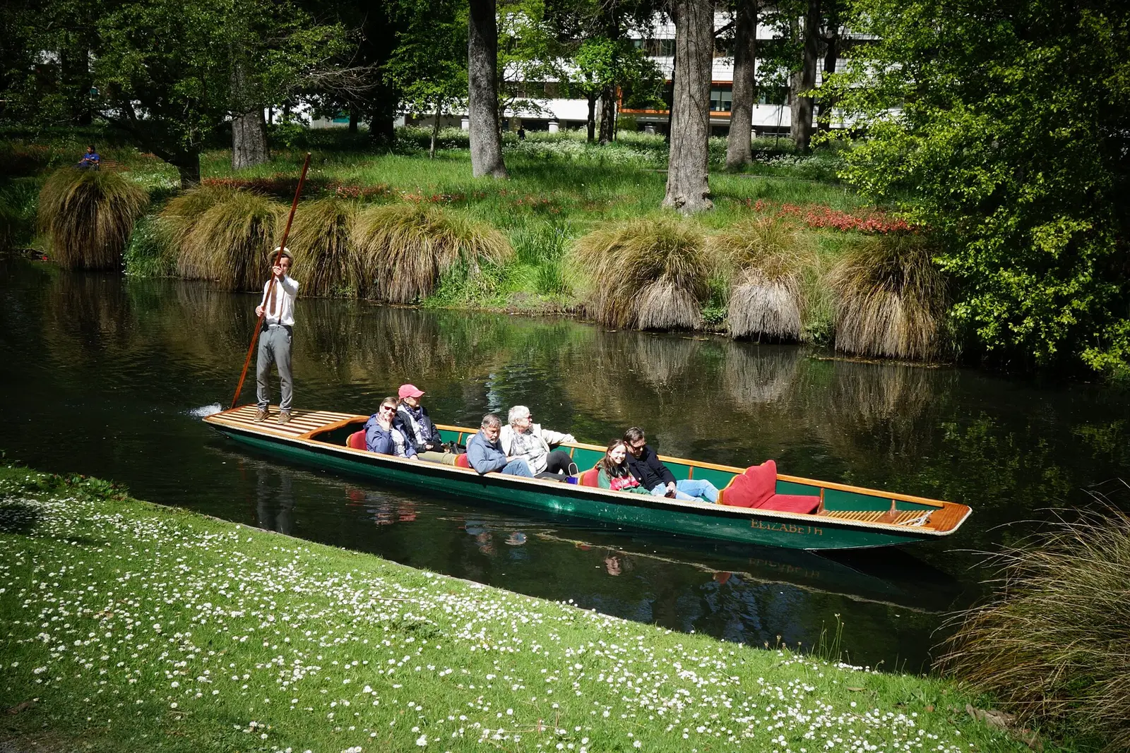A punt on the Avon River beside the lawns of Christchurch Botanic Gardens