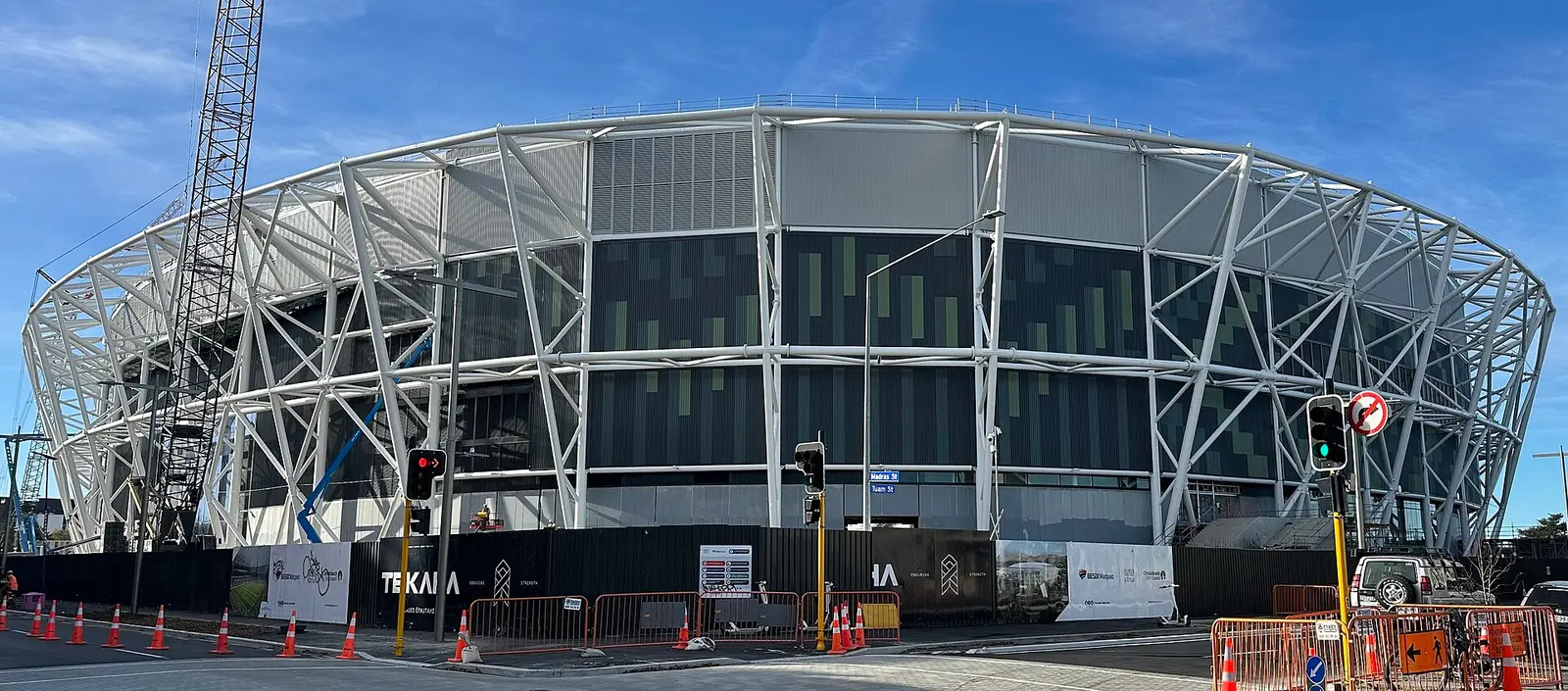 Exterior of Te Kaha stadium in Christchurch, with its steel-and-glass facade nearing completion